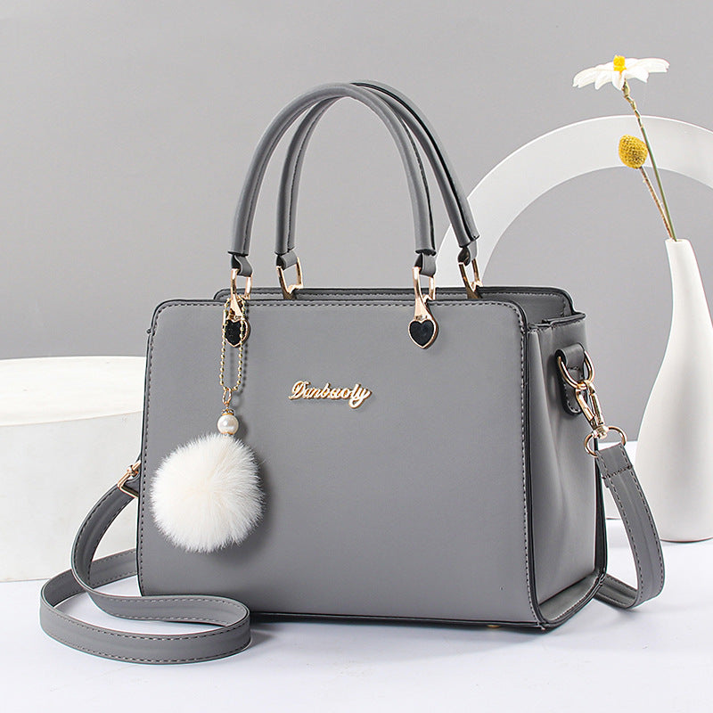 Elegant women's handbag in faux leather with tassel trim, lightweight shoulder bag in a solid color with adjustable strap, zip closure, polyester lining, lacquered edge detail - available in several colors